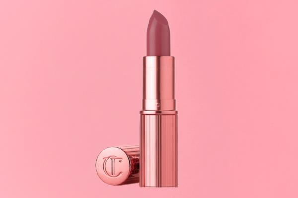 A pink lipstick with a gold tube on a gift guide cover