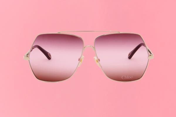 A pair of sunglasses with pink lenses on a gift guide cover