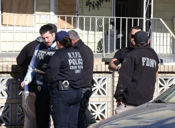 Body covered in a black tarp being wheeled from the home's garage.