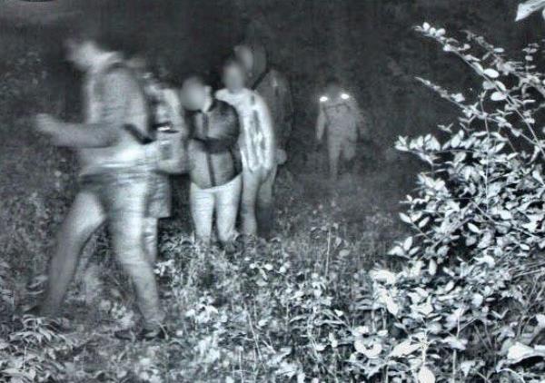 A group of Swanton Sector Agents standing in a forest on the northeastern U.S. border after apprehending over 6,100 individuals from 76 different countries