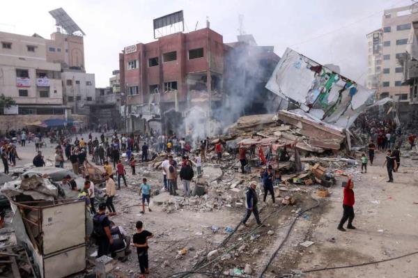 Palestinians inspect the rubble of a collapsed building in the heavily bombarded city center of Khan Yunis in the southern Gaza Strip following overnight Israeli shelling, on Oct. 10, 2023. 