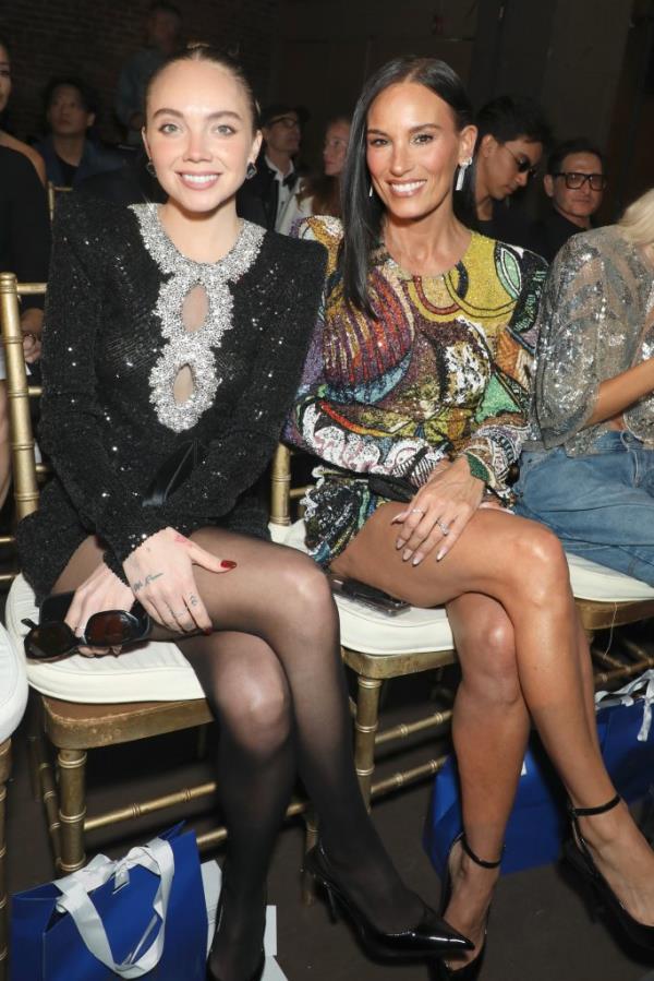 Singer Danielle Bradbery and influencer Heidi D'Amelio sitting in the front row at New York Fashion Week, twinning in sparkly minidresses.