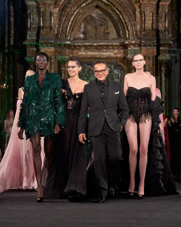 A group of people walking on a runway at Naeem Khan NYFW event