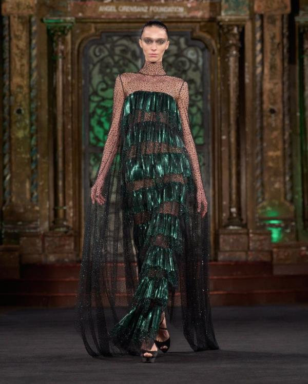 A woman modeling a fringed emerald gown at the Naeem Khan New York Fashion Week