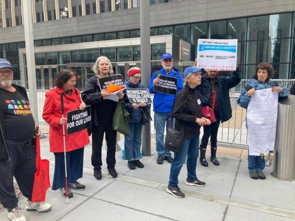 Group of UFT retirees holding signs in protest over Medicare coverage, including Kathleen Kuhfu?