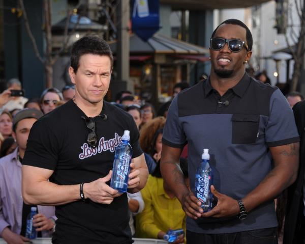 Mark Wahlberg and Sean Combs holding water bottles during their visit to 'Extra' at The Grove in Los Angeles on February 27, 2013.