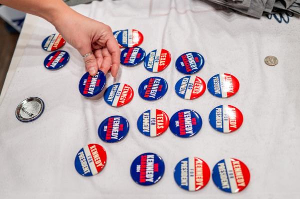 An attendee reaches for merchandise displayed on a table during a campaign rally held by Independent Presidential candidate Robert F. Kennedy Jr. at Brazos Hall on May 13, 2024 in Austin, Texas.