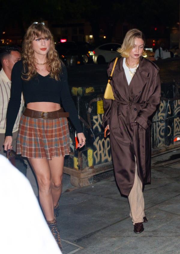 Taylor Swift and Gigi Hadid walking on a sidewalk during their girls' night out at The Corner Store restaurant in NYC