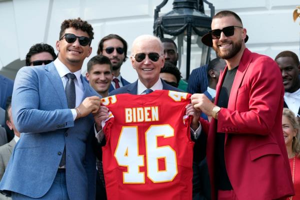 President Joe Biden receiving a Kansas City Chiefs jersey from Patrick Mahomes and Travis Kelce during their White House visit in June 2023.