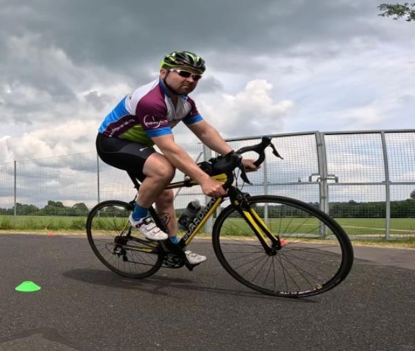 Jo<em></em>nny on a bike, wearing cyclist clothing and helmet