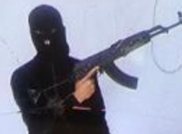 An image found on the phone of a terror suspect apprehended at the San Diego border showing a masked man holding an AK-47.