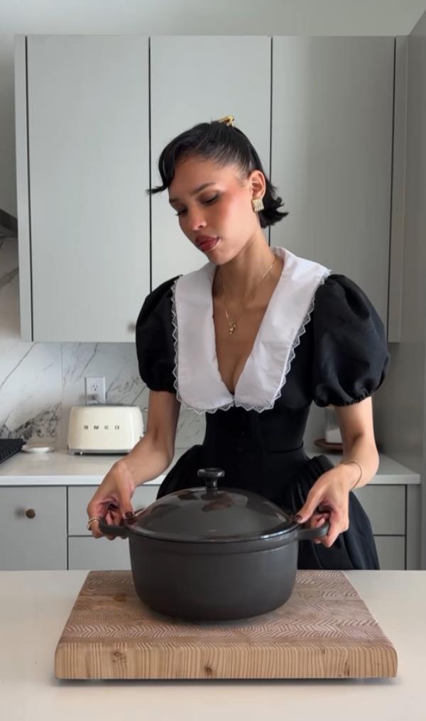 A woman in a black dress, referred to as Nara Smith, a traditio<em></em>nal wife from an Instagram post