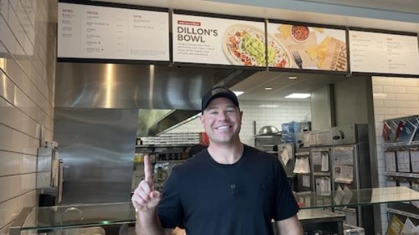 Dillon Wareham of Mobile points at a Chipotle menu advertising 